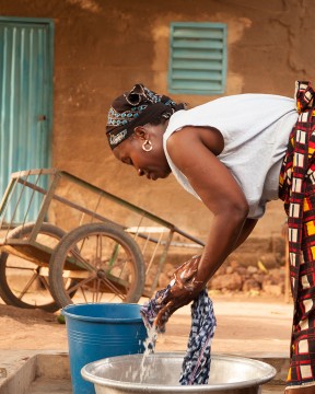 femme africaine lavant des vêtements à la main
