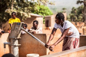 Femme qui pompe de l'eau au Burkina Faso