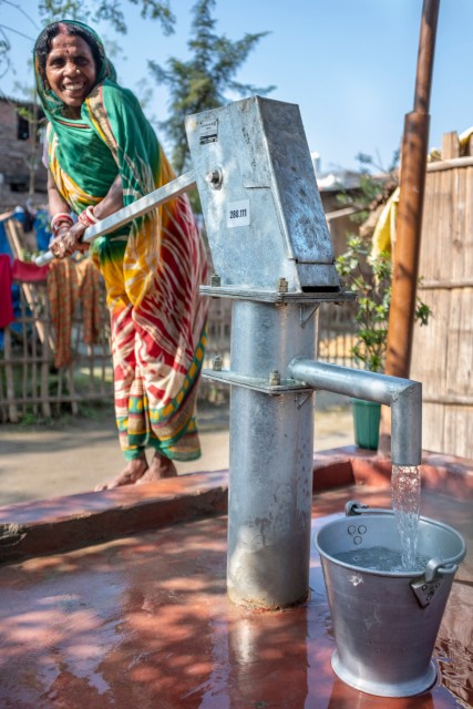 Femme qui récolte de l'eau au puit en Inde