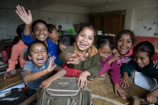 kids waving and smiling at the camera