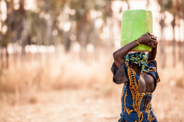 Femme qui transporte de l'eau au Burkina Faso