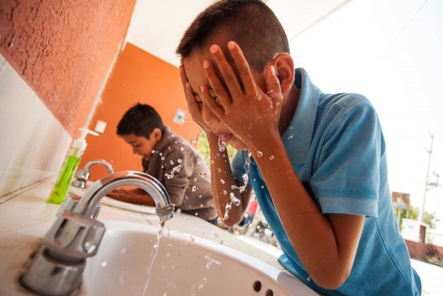 boy splashing water on his face