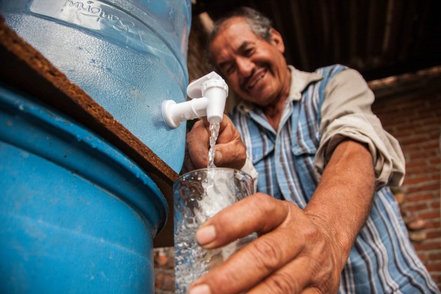 man pouring water in a glass