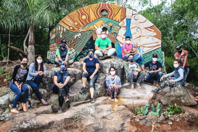 Groupe qui pose devant une murale au Paraguay