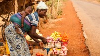 Mère et enfant qui vendent des fruits sur le bord de la route