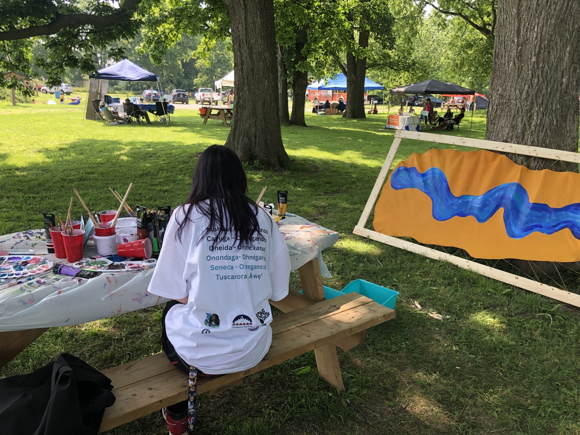 Kiosque artistique mené par One Drop en collaboration avec une artiste locale lors du festival Teiethinonhwerá:ton ne Ohné:kanos, invitant les participant·e·s à peindre des silhouettes de poissons ou écrire un message sur le thème de l’eau. Credit: Fondation One Drop